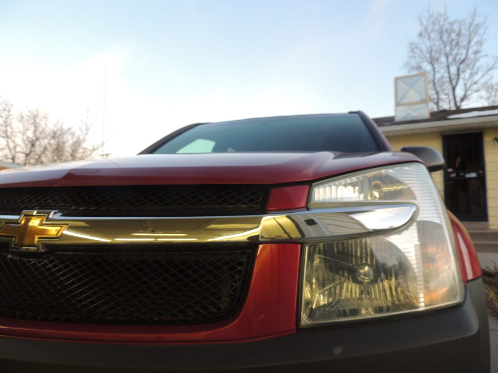 A close up of the front end of a red car.