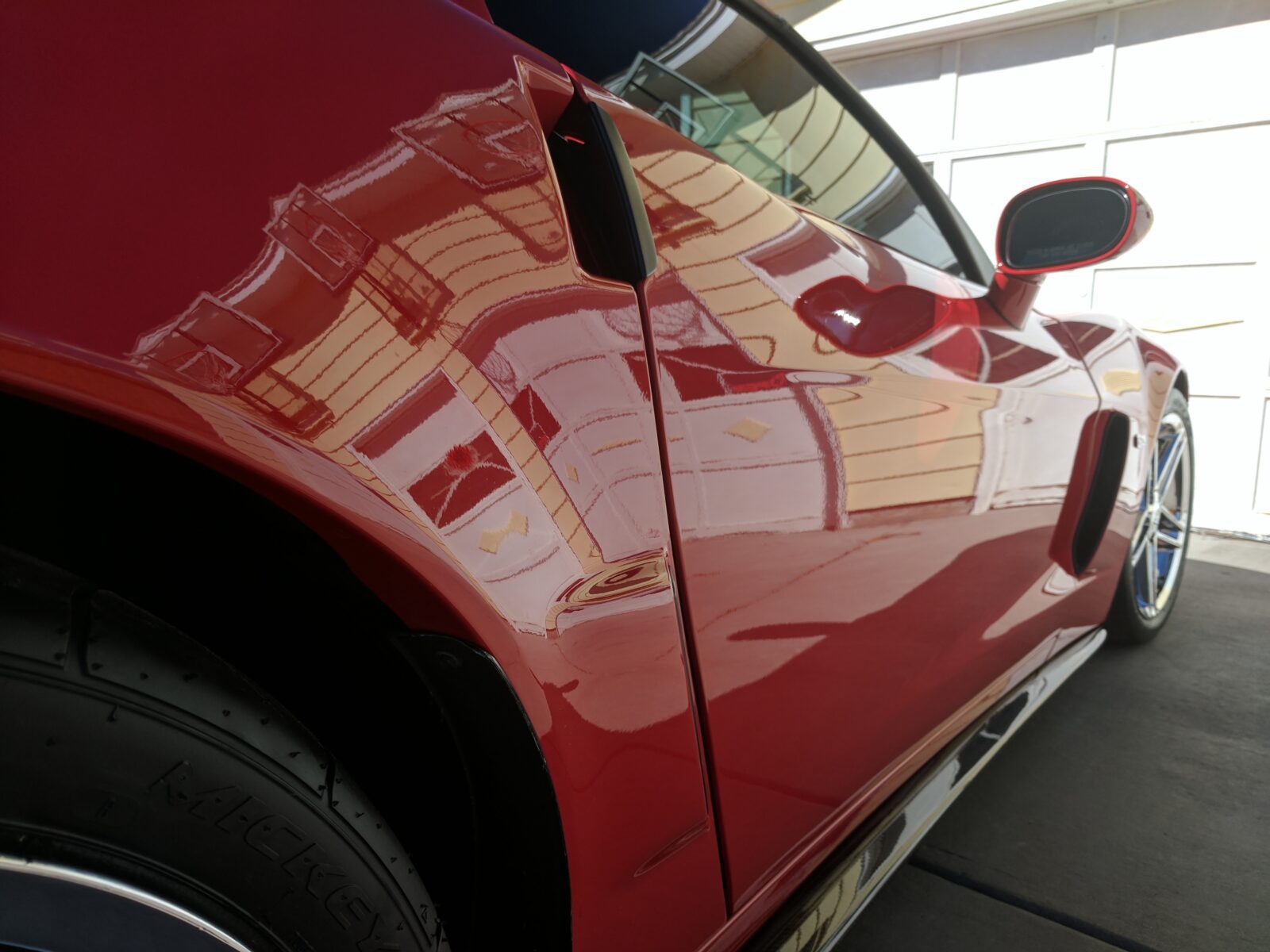 A red car with the door open and some stickers on it, after getting our Advanced Ceramic Coating in Thornton, CO