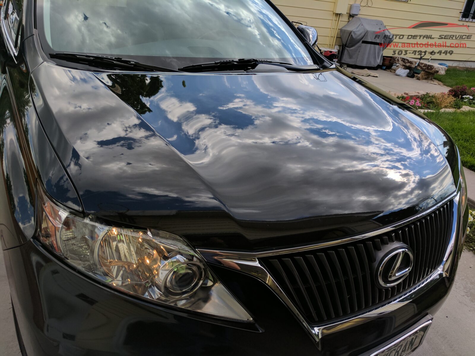 A black car with the hood up and its front end broken.